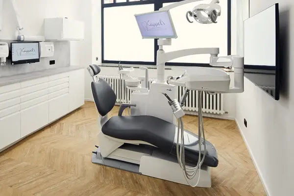 Moderne Zahnarztpraxis mit Behandlungsstuhl, digitaler Technik und heller Einrichtung.